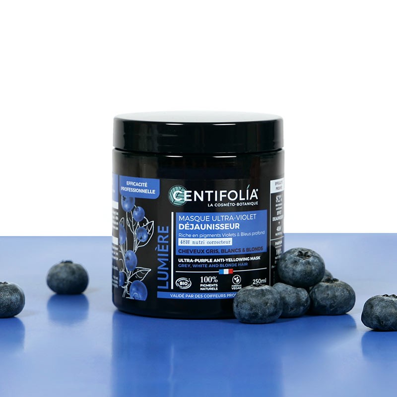 Centifolia Ultra-Purple Anti-Yellowing Mask tub on a blue desk with blueberries around the product, which are a key ingredient